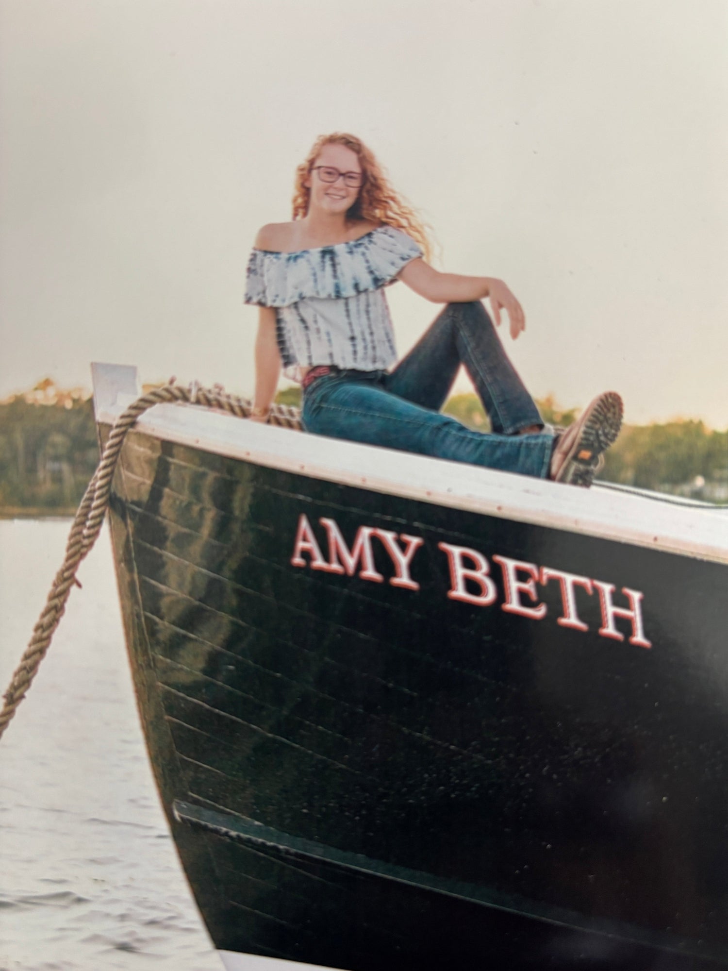 Boat named 'Amy Beth' with a person standing on it, against a white background